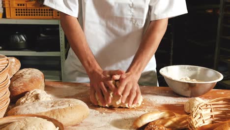 female baker kneading a dough