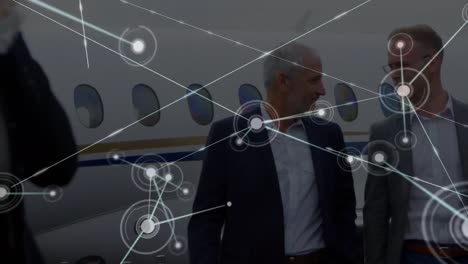 animation of network of connections over caucasian businessmen on airport