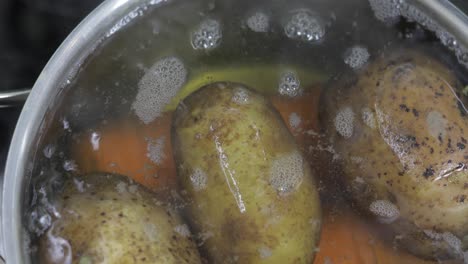 Hot-boiling-pan-with-vegetables-potatoes-and-carrots.-Cooking-in-kitchen