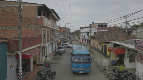 sobrevuelo aéreo de una calle en colombia con un autobús pasando lentamente por debajo