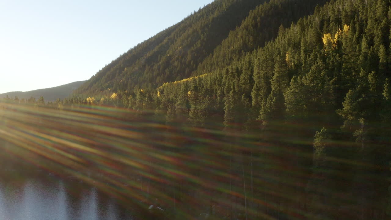 Filmato aereo con drone 4K di un'alba su un lago nelle Montagne Rocciose del Colorado in autunno, con pioppi tremuli dai colori cangianti
