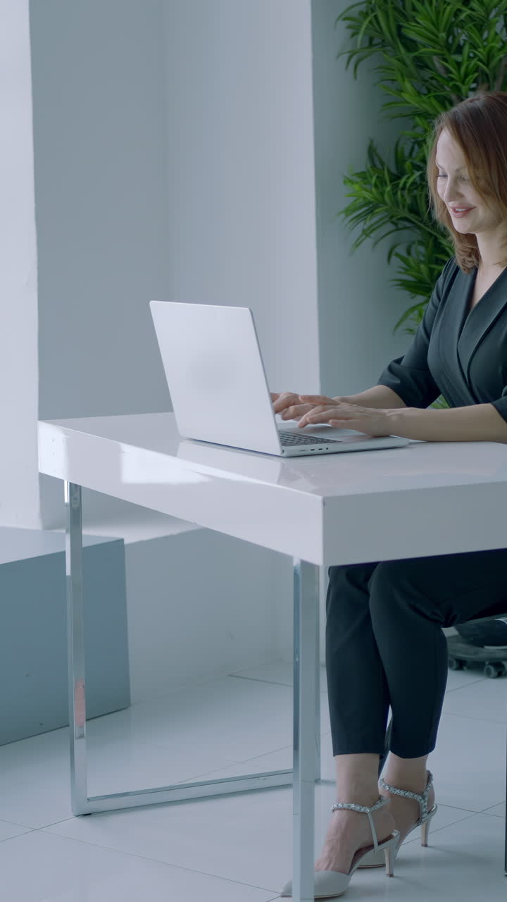 mujer trabajando en una computadora portátil en una oficina moderna