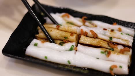 chopsticks picking up delicious rice noodle rolls