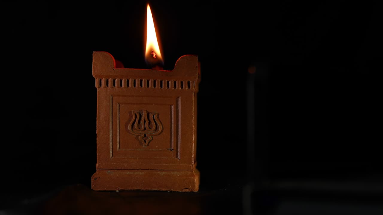 Handmade Tia (oil lamp) with the trident symbol used in Deepavali, Maha Shivaratri and many other religious festivals - Slow Motion Shot