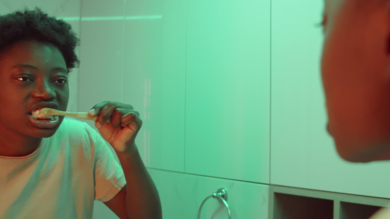 African American Woman Brushing Teeth at Home