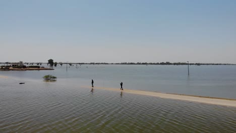 vista aérea del paisaje inundado en maher con gente caminando por la carretera que lo atraviesa