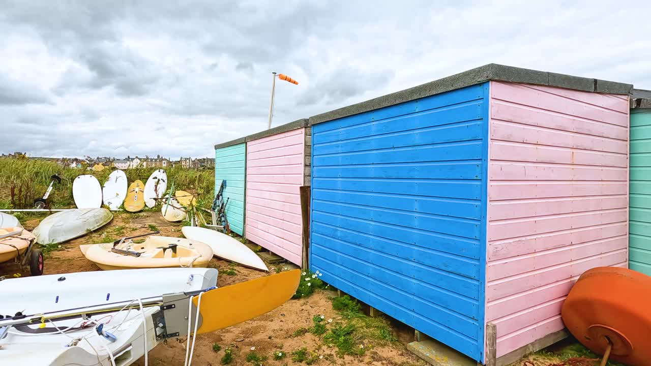 botes almacenados cerca de cobertizos coloridos por la orilla