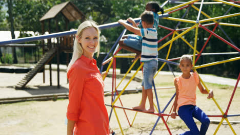 Portrait-of-happy-trainer-with-schoolkids-in-playground