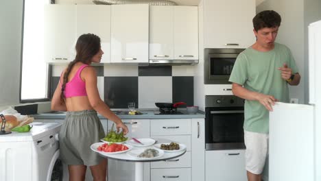 una pareja preparando una comida en una cocina