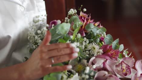 hispanic bride holding colorful bouquet of peruvian lilies