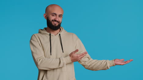 Cheerful-man-creating-ad-in-front-of-studio-camera