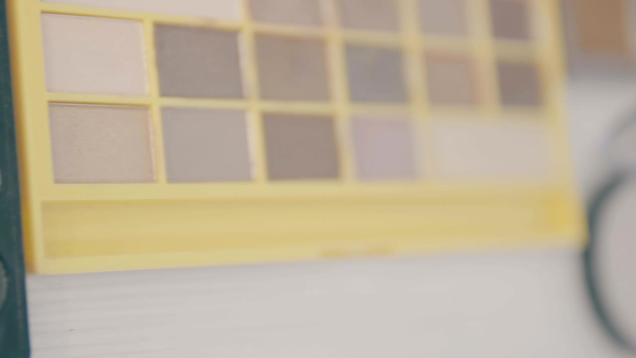 los pinceles de maquillaje que se colocan en la paleta cosmética de colores. rotación de la cámara