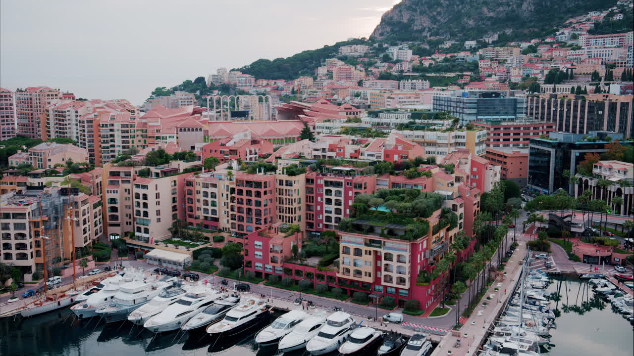View of boats docked in the Monaco Marina with the skyline of the city on the background