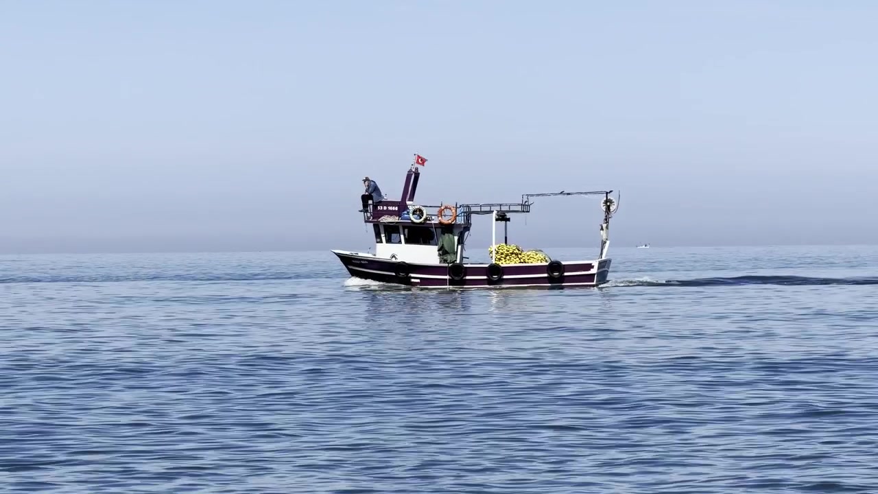 Piccola barca da pesca tradizionale si muove sulle calme acque del Golfo Persico sotto un cielo azzurro limpido, creando un paesaggio marittimo pacifico vicino alla costa di Dubai
