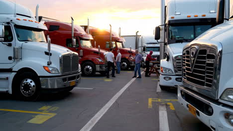 truck drivers gathered at a truck stop during sunset
