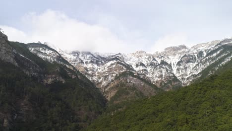 snowy mountain range with forest valley