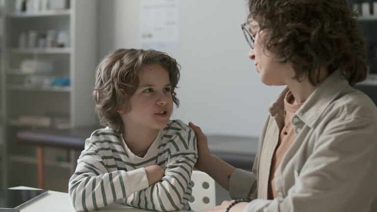 madre apoyando a su hijo pequeño durante el chequeo de salud en la oficina médica