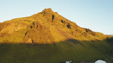imágenes de drones de un pequeño pueblo durante el amanecer con una montaña al fondo