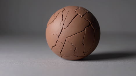 a cracked chocolate egg on a grey background