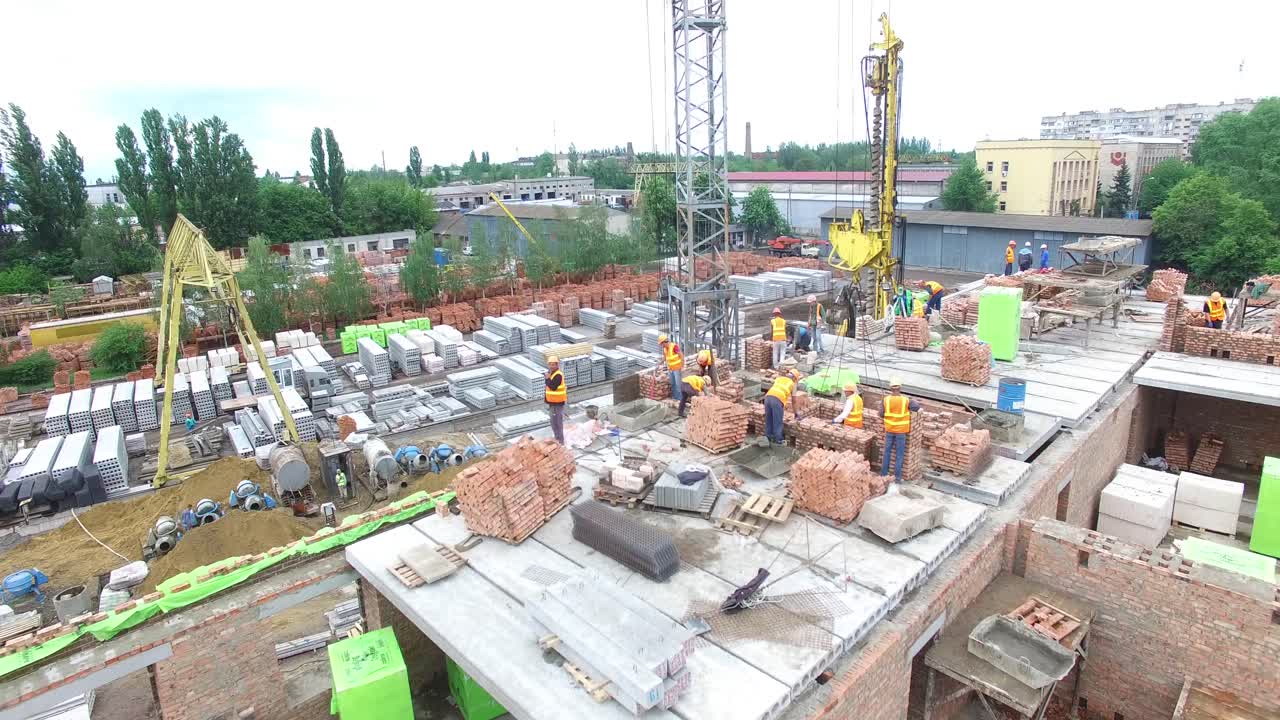 VINNITSA, UKRAINE - JUNE 2016: Aerial shot of the construction workers at a building site built in house-building