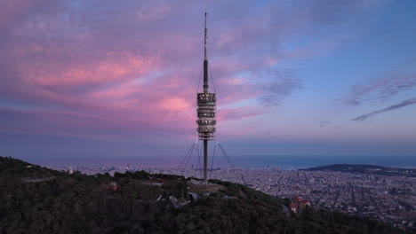 torre de comunicaciones torre de collserola al atardecer en el tibidabo con la ciudad de barcelona en el fondo, españa