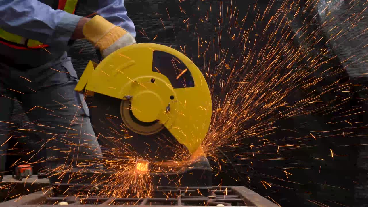 trabajador industrial en tela protectora azul usar máscara de seguridad, soldador profesional cortar estructura de acero con la emisión de chispas naranjas brillantes en la fábrica.