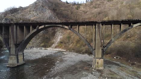 viejo puente de arco de hormigón sobre un río de montaña