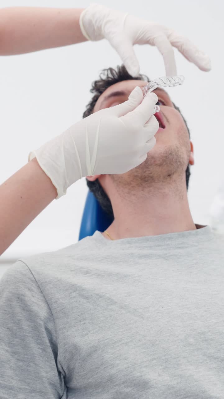 Dentista che posiziona allineatori trasparenti sul paziente