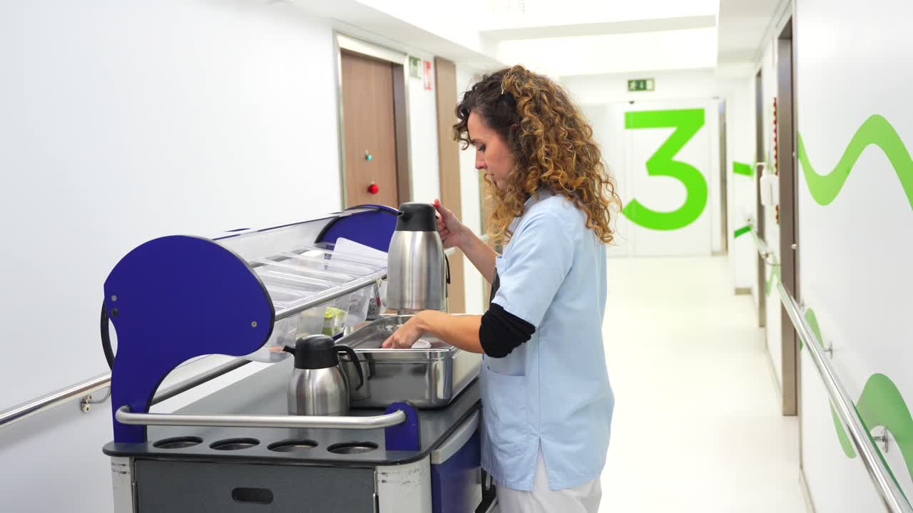 Nurse pouring drink in hospital hallway