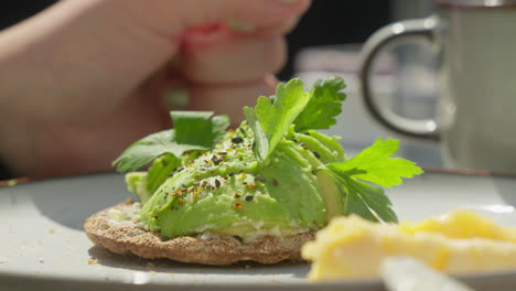 Gesunder-Frühstücksmoment:-Nahaufnahme-Einer-Avocado-Auf-Knäckebrot-Am-Sonnigen-Morgen,-Zeitlupe