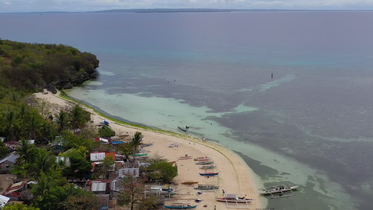 Bangka boats and huts at Hilantagaan Island Philippines with on the beach, Aerial flyover shot