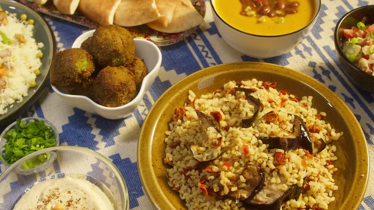 cocina árabe. bulgur con berenjena, falafel, sopa de frijoles en la mesa, cuscús con pollo. cultura tradicional de oriente medio. moutabal y ensalada de verduras en cuencos, pita. arroz delicioso con carne