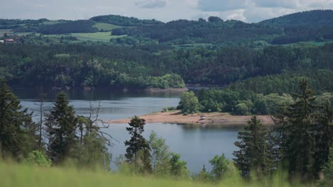 a panorama view of a tranquil vltava river surrounded by lush green hills, lush meadows, and dense forests, offering a serene natural setting in a parallax video