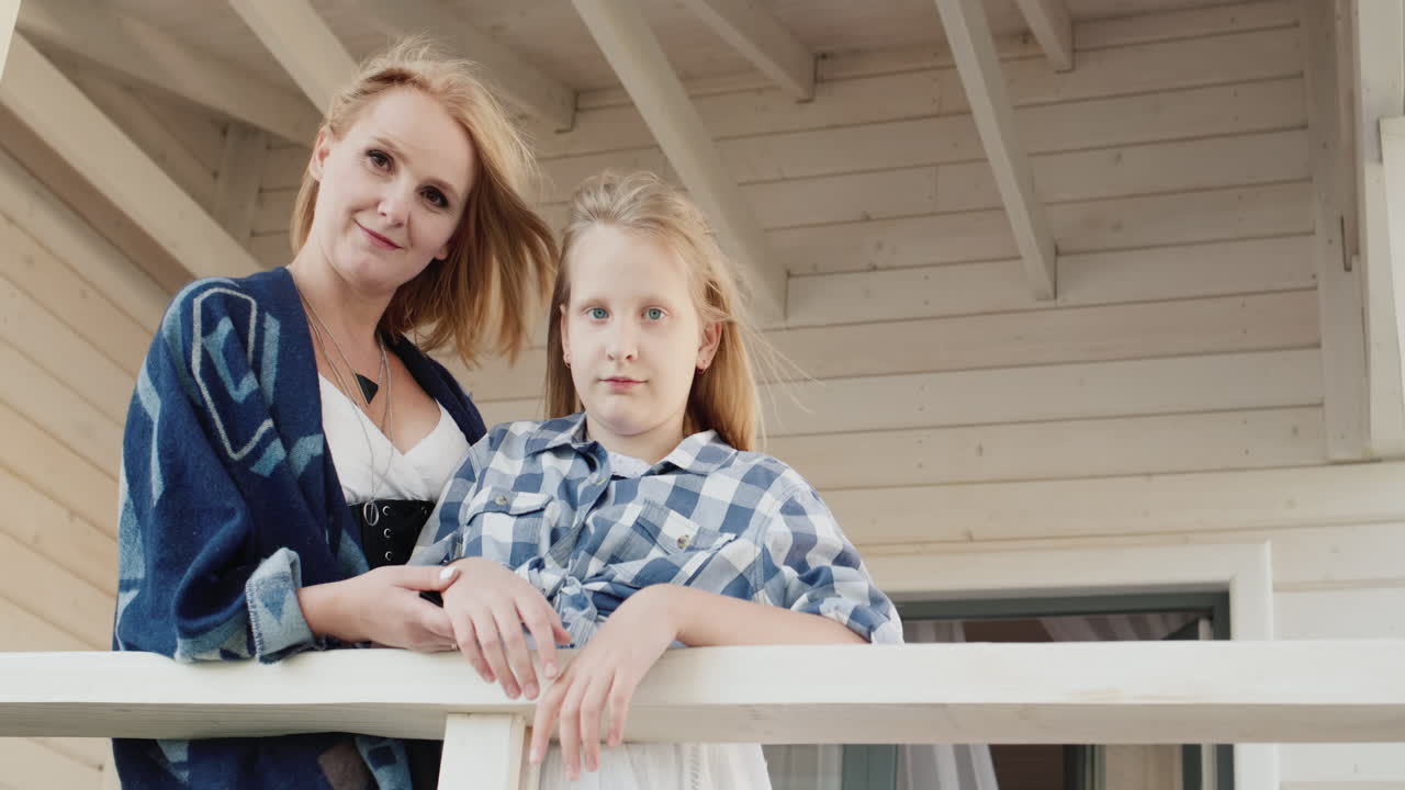 그들의 목조 주택 문앞에 그녀의 딸과 함께 어머니의 초상화