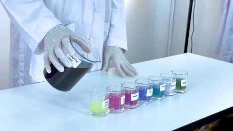 scientist pours liquid into beakers, causing color changes. bright lighting, laboratory setting, and precise movements highlight chemical reactions