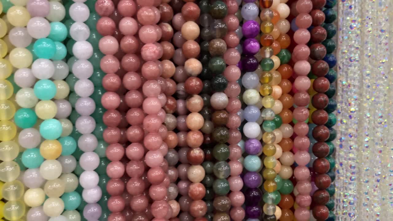 Multicolor children's necklaces and bead bracelets on a shop display. Bright jewelry with plastic flowers and figures, concept of kids fashion, gifts, and accessories for girls