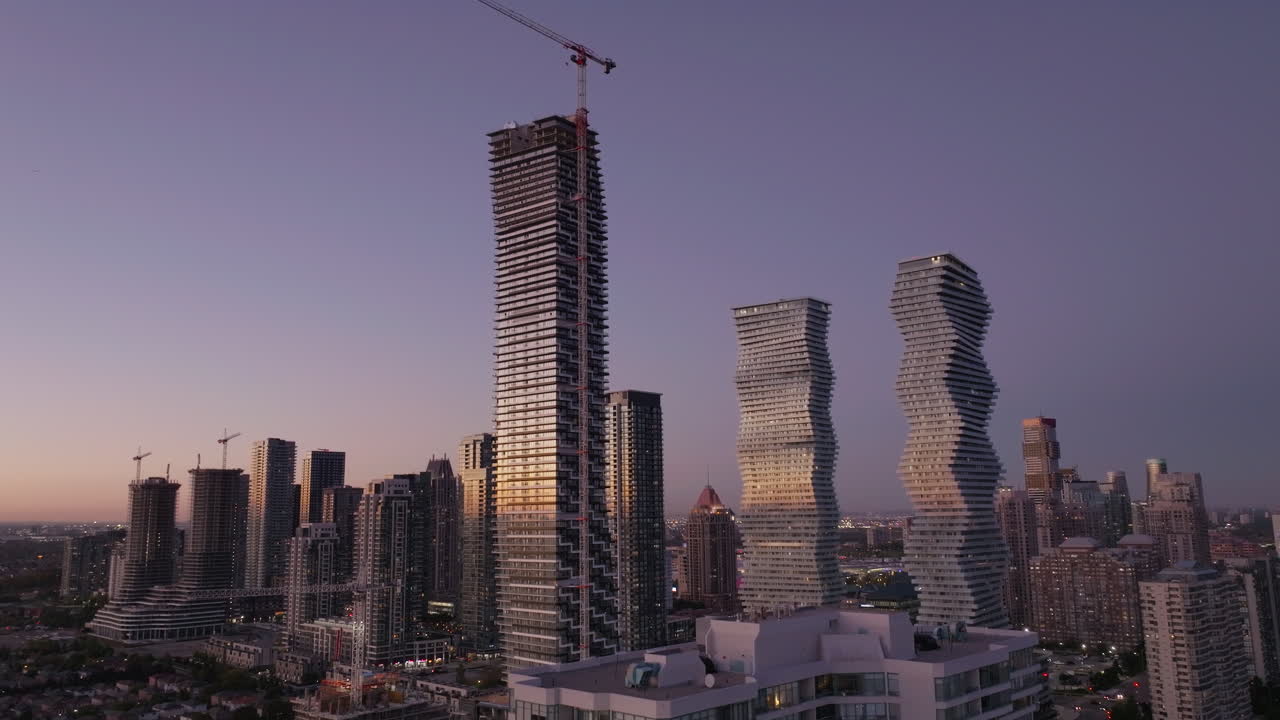 Paisaje urbano de Mississauga al atardecer con modernos rascacielos y grúas visibles