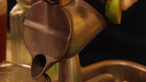 close-up of gloved hands operating a metal citrus juicer with precision and care.