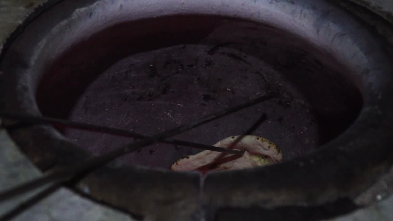 Person cooking cheese filled Naan bread at an Indian food court In Vietnam