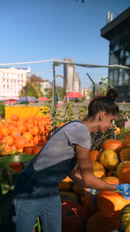 woman picking pumpkins at a fall market