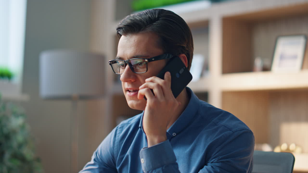Stressed man disputing telephone call at work room close up. Businessman arguing