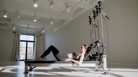 woman practicing pilates on a reformer