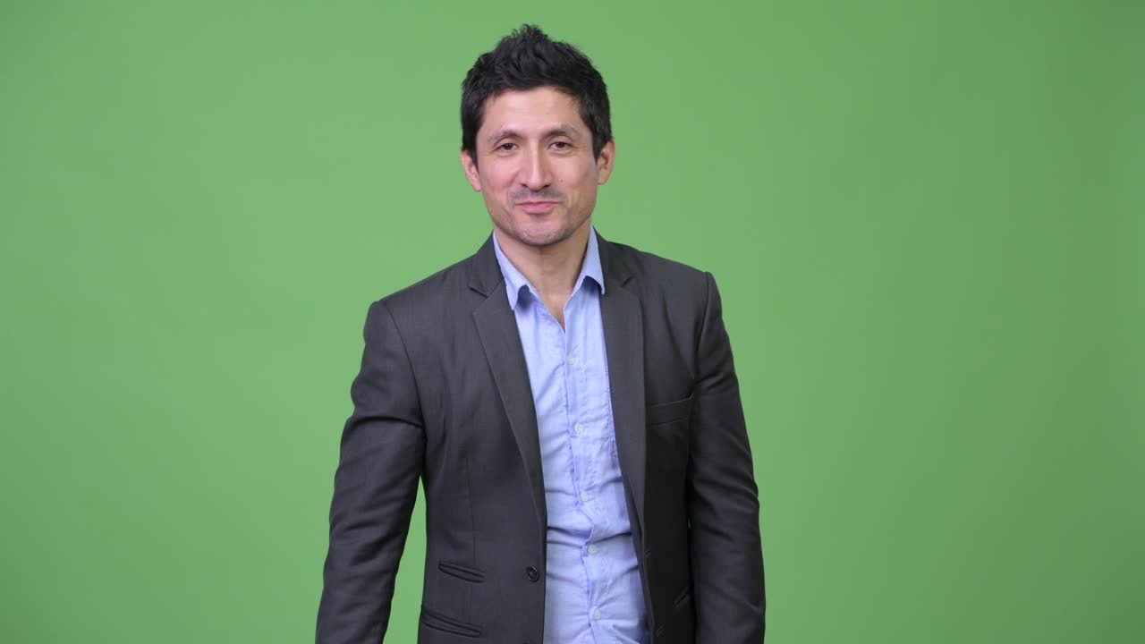 Happy Hispanic businessman giving thumbs up