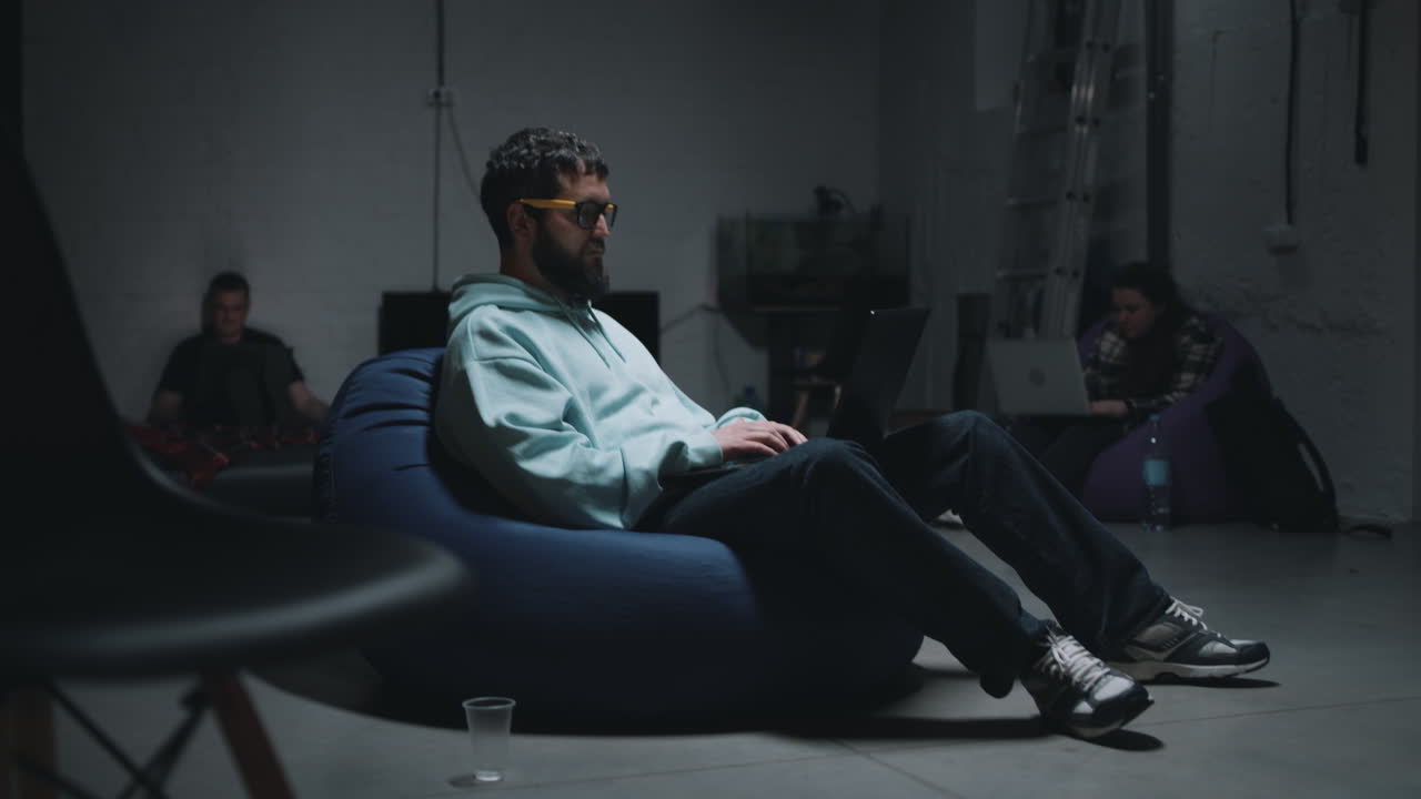 Man working on laptop in a dark room