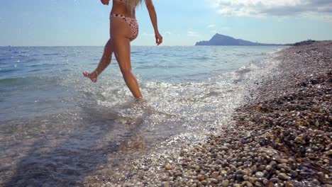 Eine-Frau-Im-Bikini-Betritt-Das-Wasser-Des-Mittelmeers-Und-Tritt-Mit-Ihnen-Ins-Wasser