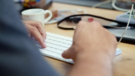 mani di uomo che scrivono su una tastiera di un computer portatile