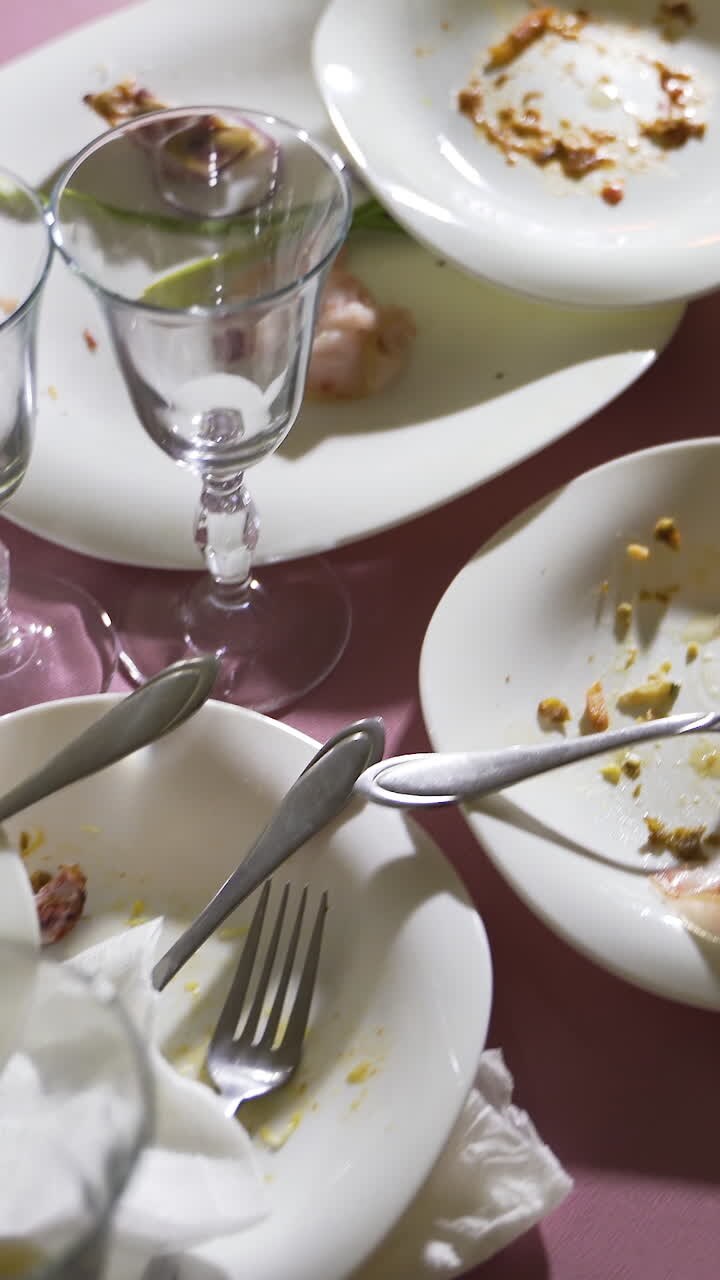 leftovers on white dishes are on the festive table. Camera motion forward Vertical video