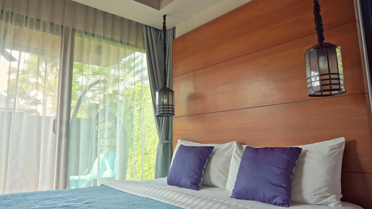 Tilt down shot, modern hotel bedroom with clean made up bed and balcony