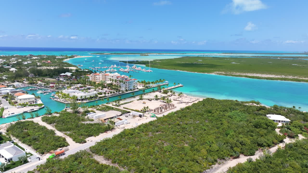 공중 드론은 해안가의 집, 지나가는 보트 및 다리를 가진 운하를 통해 앞으로 순항했습니다.