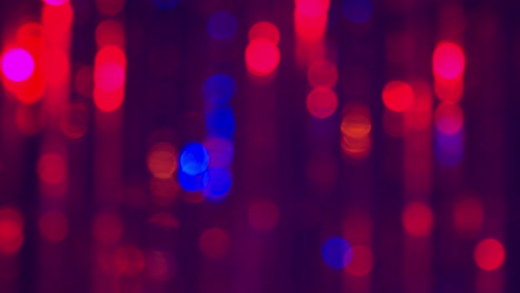 defocused close up shot of sparkling tinsel curtain in night club or disco with flashing strobe lighting